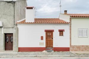 CampinhoCasa da Junqueira - Lago do Alqueva的白色的建筑,有红色和白色的门