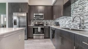 Fort Myers VillasLanding Modern Apartment with Amazing Amenities (ID8083X42)的厨房配有木制橱柜和不锈钢用具