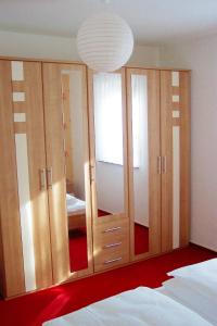 KottmarsdorfFerienwohnung Kottmarsdorf的一间卧室设有木制橱柜和大镜子