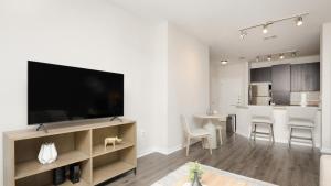 坦帕Landing Modern Apartment with Amazing Amenities (ID7605X82)的带平面电视的客厅和厨房。
