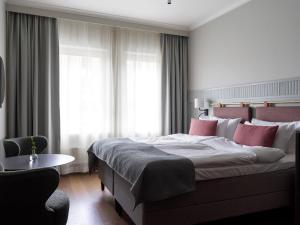 斯德哥尔摩Elite Palace Hotel & Spa的卧室配有一张带粉红色枕头的大床