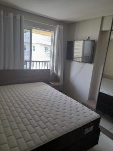 福塔莱萨Villa damasco的一间卧室配有一张床和一台平面电视