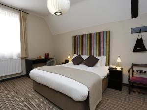 剑桥红狮酒店的一间设有大床和窗户的酒店客房