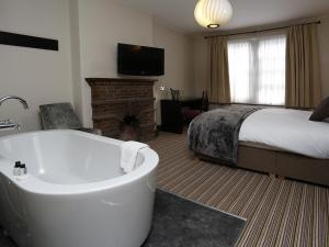 剑桥红狮酒店的带浴缸和床的酒店客房