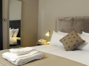 剑桥红狮酒店的一间卧室配有带毛巾的床