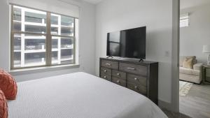 休斯顿Landing - Modern Apartment with Amazing Amenities (ID1403X404)的一间卧室配有一张床,梳妆台上配有电视