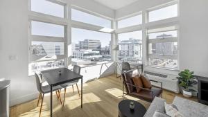 丹佛Landing - Modern Apartment with Amazing Amenities (ID1401X734)的客厅配有桌子和一些窗户