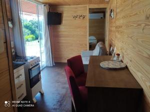 巴热Casa Container Amarela的一间带桌子和炉灶的厨房以及一间客房。