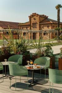 巴塞罗那Torre Melina, a Gran Meliá Hotel的一个带桌椅的庭院和一座建筑