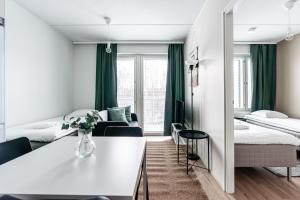 海门林纳SPOT Apartments Hämeenlinna的酒店客房设有两张床和一张桌子。