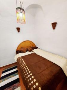 卢克索Villa Cleopatra Luxor west bank的一间卧室配有一张带吊灯的大型木床。