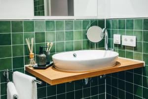 格罗瑙LIVELY Weiße Dame Gronau的绿色瓷砖浴室设有水槽和镜子