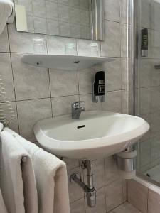 因河畔布劳瑙City Hotel Post 12的浴室配有盥洗盆、镜子和毛巾