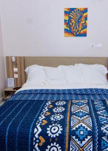 克里比BUNGALOW'S PLAZA KRIBI的床上有蓝色和白色的毯子