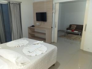 阿尔塔弗洛雷斯塔Lisboa Palace Hotel的一间卧室配有一张带白色床单的床和一台电视。