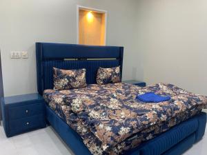 拉瓦尔品第Park View Residency的一间卧室配有蓝色的床和蓝色床头板