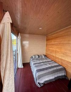 马瑙斯Flutuante Long Beach Manaus Am的木制客房的一张床位,设有窗户