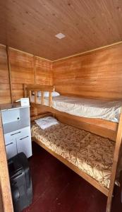 马瑙斯Flutuante Long Beach Manaus Am的小房间设有两张双层床和一台冰箱