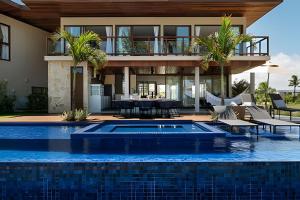 普拉亚多Luxo a 50 m da praia, acesso ao Iberostar Resort的房屋前有游泳池的房子
