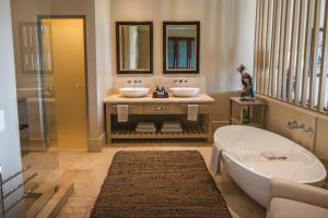 帕尔Santé Wellness Retreat & Spa的浴室配有两个盥洗盆和浴缸。