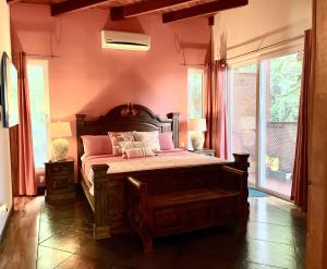 西湾Casa Maya的卧室配有一张带粉红色墙壁的大床
