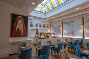 佛罗伦萨金塔温泉酒店的用餐室配有桌椅和彩色玻璃窗