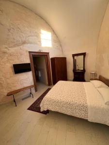 马泰拉洛库斯阿美努斯旅馆的一间卧室配有一张床和镜子