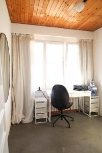 布鲁塞尔Furnished - Bright, Modern apartment in Brussels, 15 minutes walk from the Atomium的窗户前配有书桌和椅子的房间