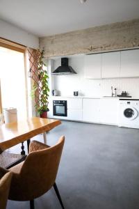 布鲁塞尔Furnished - Bright, Modern apartment in Brussels, 15 minutes walk from the Atomium的厨房配有白色橱柜和桌椅