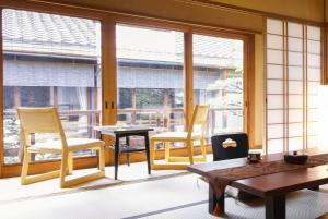 京都桑加旅馆的配有椅子和桌子的房间,窗户
