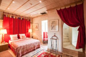 莱梅雷Hôtel du Château du Rivau的一间卧室配有红色窗帘、一张床和淋浴