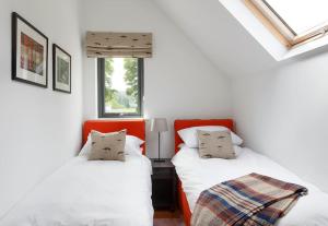 珀斯Stalker's Lodge的配有2张床的白色墙壁和窗户客房