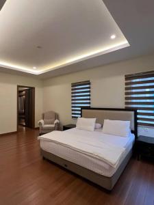 Gadok 1NEW! Luxurious Villa @ Vimala Hills (15 pax)的一间卧室配有一张大床和一把椅子