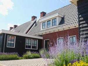 科莱恩斯普拉特Beautiful holiday home in Colijnsplaat with garden的红砖房子,设有瓷砖屋顶