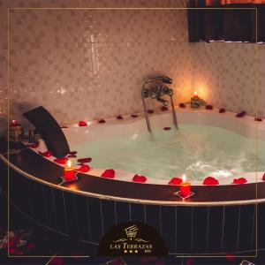安达韦拉斯HOTEL LAS TERRAZAS INN的浴缸内装有水龙头和蜡烛