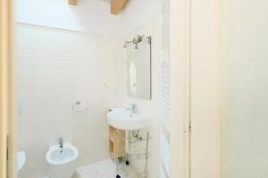 科莫卡萨迪玛利亚旅馆的白色的浴室设有水槽和卫生间。
