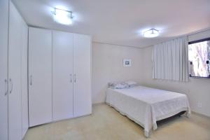 巴西利亚Chalé Lago Norte的白色的卧室设有床和窗户