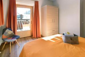 利维尼奥Mountain Apartments Livigno的卧室配有床、椅子和窗户。