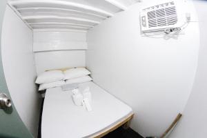 宿务Dickem's Transient House的一间小型白色客房,配有空调