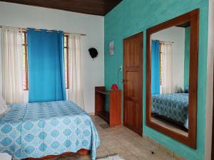 TilaránLa Ceiba Tree Lodge的一间卧室配有一张床和镜子
