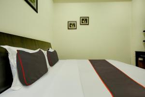 贾朗达尔Ovel Hotel Grand的一间卧室配有一张带黑白枕头的床