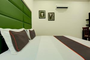 贾朗达尔Ovel Hotel Grand的一间卧室配有一张带绿色床头板的床