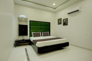 贾朗达尔Ovel Hotel Grand的一间卧室配有一张大床和绿色床头板