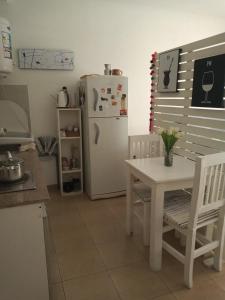 布宜诺斯艾利斯Departamento Villa Urquiza的厨房配有白色的桌子和冰箱。