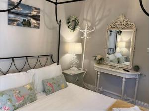 鲍内斯温德米尔斯托尔斯大门别墅酒店的一间卧室配有一张带镜子和桌子的床