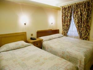 伦敦格雷舍姆酒店的酒店客房设有两张床和窗户。