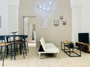 CarmianoTre Balconi - Casa Vacanza Salento的客厅配有桌椅和电视。