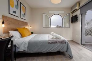 马拉加Nordik Rooms Urban - Segalerva "Geiranger"的一间卧室设有一张大床和两个窗户。