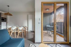 里昂Suite Croix-Rousse : T3 avec patio !的一间带蓝色沙发的客厅和一间用餐室