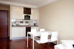 瓦伦西亚One bedroom apartement with wifi at Mislata的厨房配有白色的桌子和白色的椅子